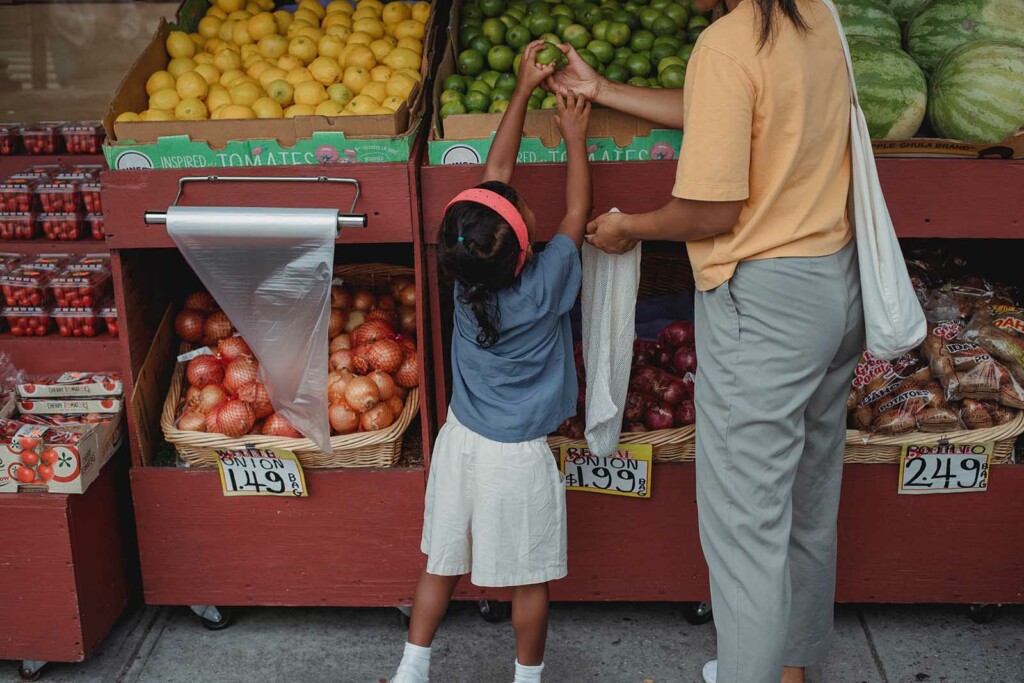 Kind hilft bei Einkauf um nachhaltigen Konsum selbst zu lernen
