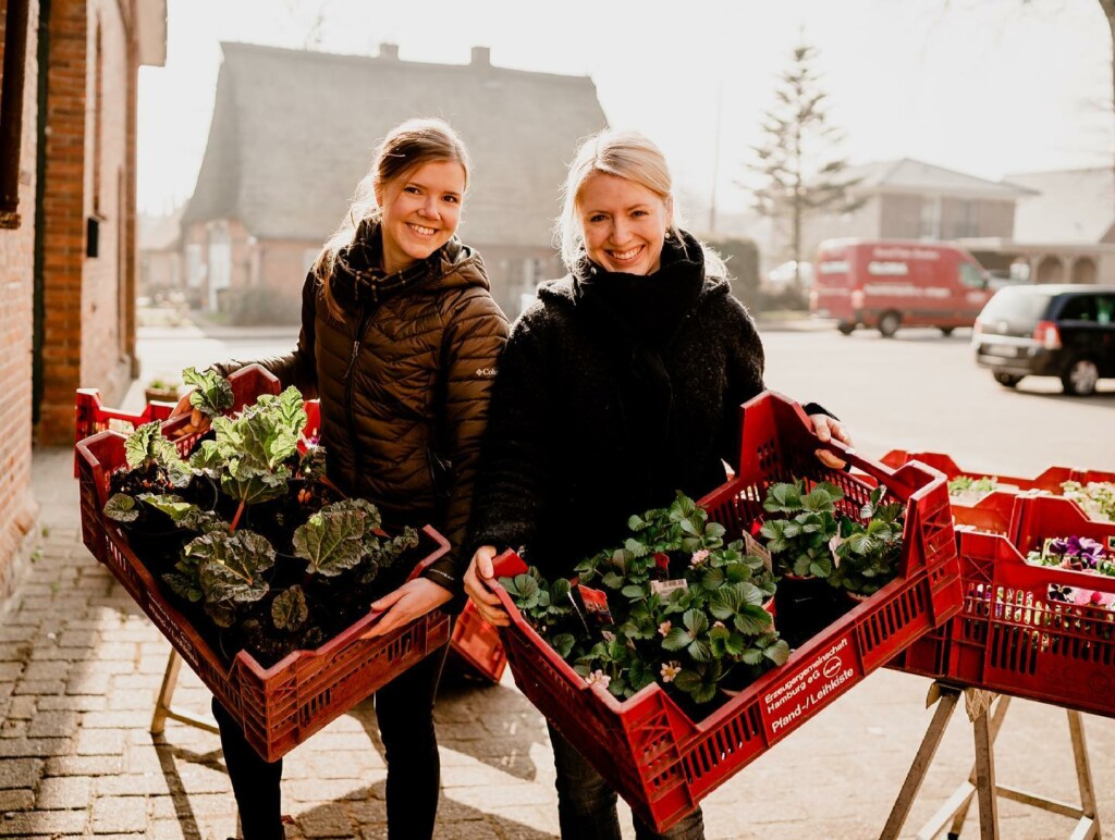 Frauen präsentieren nachhaltig angepflanztes Gemüse