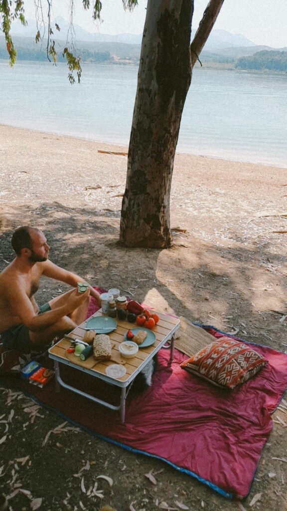 Mann macht Camping Frühstück am Meer