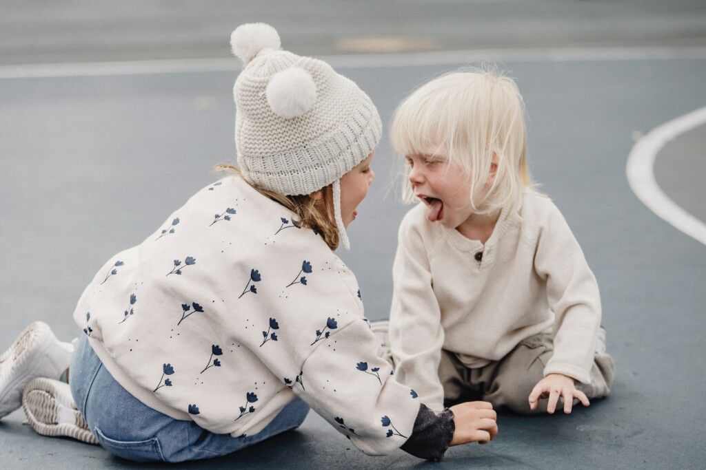 Zwei Kinder spielen in der kalten Jahreszeit draußen