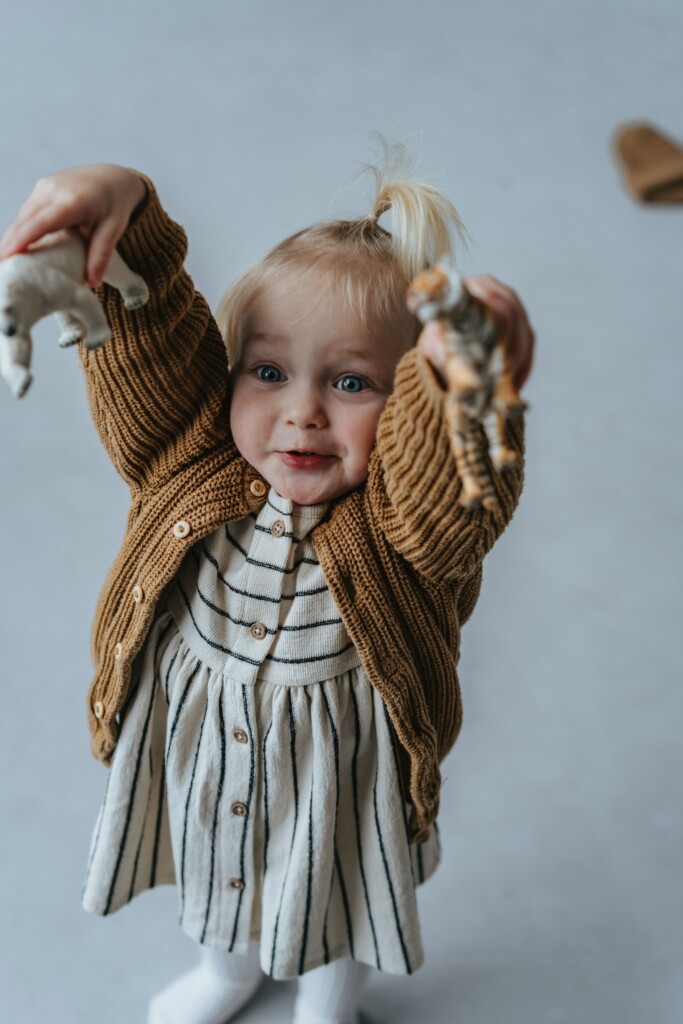 Kind zeigt Holzspielzeug anstatt Bildschirme. Auch letztere hängen mit dem kindlichen Immunsystem zusammen.